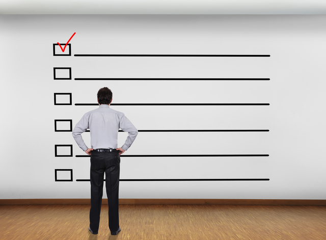 businessman in office looking at wall with checklist concept